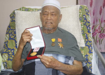 MD. Nen Kasim menunjukkan Pingat Emas Semai Felda pertama yang diterima sebagai pengiktirafan jasanya dalam mengangkat kegemilangan Felda di mata dunia. – MINGGUAN/SALEHUDIN MAT RASAD