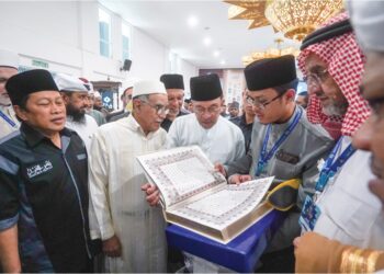 ANWAR Ibrahim melihat naskhah al-Quran beserta terjemahan pada pelancaran percetakan al-Quran dan terjemahan dalam bahasa Russia di Putrajaya, semalam. – UTUSAN/FAISOL MUSTAFA