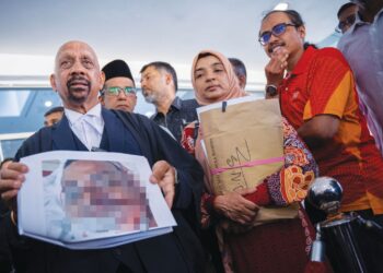 NARAN Singh bersama Ummu Haiman Bee Daulatgun menunjukkan kecederaan fizikal Allahyarham Syamsul Haris Shamsudin di Mahkamah Tinggi Shah Alam, semalam. – UTUSAN/SADDAM YUSOFF