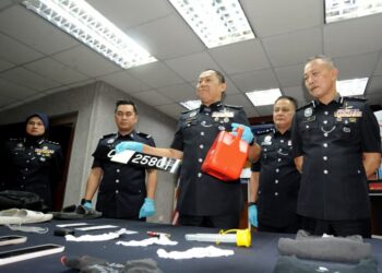 AB Rahaman Arsad menunjukkan tong minyak yang digunakan pasangan kekasih untuk membakar rumah mangsa dalam sidang akhbar di IPK, Johor Bahru, hari ini. - UTUSAN/RAJA JAAFAR ALI