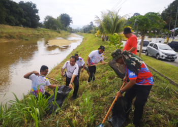 Penduduk setempat bergotong-royong membersihkan teping Sungai Paroi pada Program Gotong-Royong Perdana @stesen #3 di tebing Sungai Paroi, Ampangan di sini hari ini. - UTUSAN /NUR SHARIEZA ISMAIL