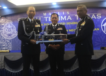 RUSDI Mohd. Isa (tengah) menyaksikan serah tugas antara Ahmad Dzaffir (kiri) dan Alzafny di IPK Negeri Sembilan di Seremban hari ini.-UTUSAN /NUR SHARIEZA ISMAIL