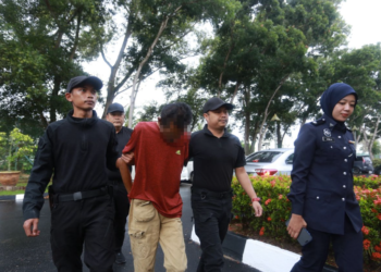 TERTUDUH dibawa oleh anggota polis bagi menghadapi 13 pertuduhan rogol dan cabul empat anak tirinya di Mahkamah Sesyen Alor Setar. Kedah/- UTUSAN/ SHAHIR NOORDIN
