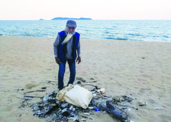 CHE YAK @ Embong Ngah menjadikan aktiviti berjalan menyusuri pantai sambil mengutip sampah sebagai riadah di Pantai Rhu Muda dan sekitarnya ketika ditemui di Marang semalam. - MINGGUAN /NOOR HAYATI MAMAT