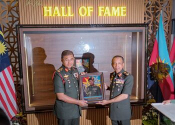 Mohd Nizam Jaffar (kiri) menerima cenderahati daripada Komandan Maktab Ketahanan Nasional, Brigedier Jeneral Abdul Karim Ahmad (kanan) selepas Majlis Pemasyhuran "Hall of Fame" kepada personaliti pertama Maktab Ketahanan Nasional di Maktab Ketahanan Nasional Putrajaya, semalam.  UTUSAN/FAIZ ALIF ZUBIR/PEMBERITA - HUSNI