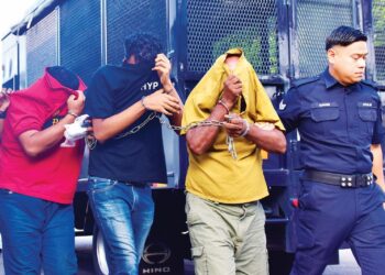 TERTUDUH diiringi anggota polis selepas dihadapkan di Mahkamah Majistret Jasin semalam atas pertuduhan membunuh seorang lelaki pada 27 Julai lalu. – UTUSAN/ARIF HAMIZAN MISKON