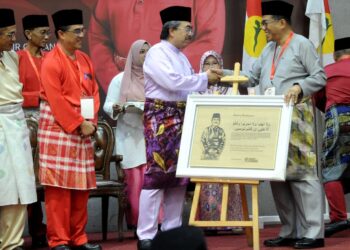 MOHAMED Khaled Nordin (kanan) bersalaman dengan Johari Abdul Ghani pada Mesyuarat Perwakilan UMNO Bahagian Pasir Gudang di Dewan Muafakat Taman Mawar, Johor Bahru, Johor. - UTUSAN/RAJA JAAFAR ALI