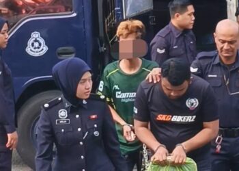 TERTUDUH (memegang beg plastik) ketika dibawa ke Mahkamah Majistret Balik Pulau, Pulau Pinang hari ini.