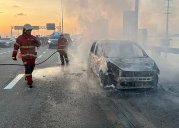 ANGGOTA bomba bertungkus-lumus memadam kebakaran melibatkan sebuah Perodua Myvi di atas Jambatan Pulau Pinang, hari ini.-GAMBAR/JBPM PULAU PINANG