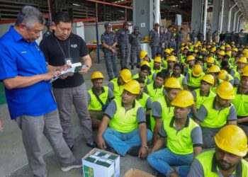 ZAKARIA Shaaban (berdiri, kiri) ketika turut-serta dalam satu operasi bersepadu oleh Jabatan Imigresen Malaysia (JIM) di sebuah kilang di Simpang Ampat, Pulau Pinang hari ini.-UTUSAN/DANIAL SAAD