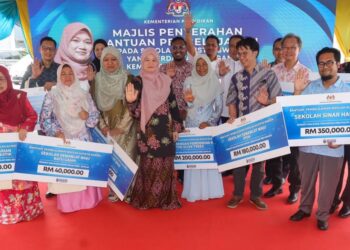FADHLINA Sidek (tengah) bergambar bersama penerima cek cura pada Majlis Penyerahan Cek Cura Sekolah Autistik di Sekolah Sinar Harapan di Bukit Mertajam, Pulau Pinang hari ini. - UTUSAN/DANIAL SAAD