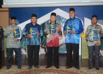 MOHD. Ali Mohd. Rustam menunjukkan Buku Panduan Pendaftaran Koperasi Kariah Masjid dan Surau Negeri Melaka yang dilancarkan di Auditorium Masjid Al-Azim, Bukit Palah, Melaka. - UTUSAN/AMRAN MULUP