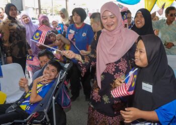 FADHLINA Sidek (dua dari kanan) menyanyikan lagu ‘Jalur Gemilang’ bersama murid istimewa pada Majlis Penyerahan Cek Cura Sekolah Autistik di Sekolah Sinar Harapan, Bukit Mertajam, Pulau Pinang hari ini. -UTUSAN/DANIAL SAAD