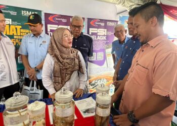 RUZIAH Shafri (tengah) menyaksikan pameran perikanan di Tok Bali, Pasir Puteh, Kelantan. - UTUSAN/TOREK SULONG