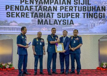 NOR Hisham menyampaikan sijil pendaftaran pertubuhan kepada Tengku Ab. Aziz Tengku Mahmud sebagai simbolik jalinan kerjasama pada Majlis Perhimpunan Bulanan Peringkat Ibu Pejabat JBPM Bulan Julai 2025 di Putrajaya. - UTUSAN/KAMARIAH KHALIDI