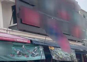 TANGKAP layar satu rakaman video yang tular menunjukkan dua individu yang dilihat seperti sengaja memasang Jalur Gemilang secara terbalik di sebuah kedai di Kepala Batas, Pulau Pinang.-GAMBAR/FACEBOOK