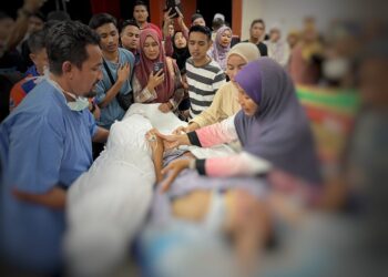 TUAN Nor Syuhada Mohd. Zain sempat melihat jenazah suami dan dua anaknya walaupun dalam keadaan terbaring semasa dibawa ke Jabatan Forensik Perubatan Hospital Gua Musang, Kelantan hari ini-UTUSAN/AIMUNI TUAN LAH.