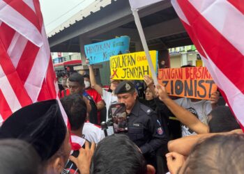 SEORANG anggota polis (tengah) dilihat tenang ketika cuba mengawal keadaan apabila beberapa individu serta wakil dari Lawyers For Liberty melakukan provokasi terhadap kumpulan peserta Himpunan Solidariti Jalur Gemilang di Kepala Batas, Pulau Pinang hari ini.-UTUSAN/SITI NUR MAS ERAH AMRAN