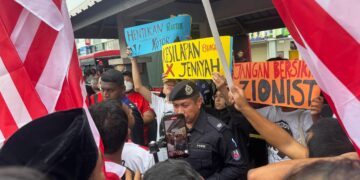SEORANG anggota polis (tengah) dilihat tenang ketika cuba mengawal keadaan apabila beberapa individu serta wakil dari Lawyers For Liberty melakukan provokasi terhadap kumpulan peserta Himpunan Solidariti Jalur Gemilang di Kepala Batas, Pulau Pinang hari ini.-UTUSAN/SITI NUR MAS ERAH AMRAN