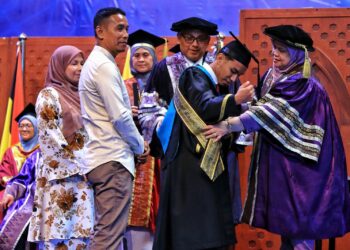 MUHAMMAD Fathur Rahman Mohd. Sani menerima Anugerah Menteri Kemajuan Desa dan Wilayah (Graduan Keseluruhan Terbaik) yang disampaikan oleh Rubiah pada Majlis Konvokesyen UCAM Kali ke-21 di Nilai, Seremban hari ini.-UTUSAN/MOHD. SHAHJEHAN MAAMIN