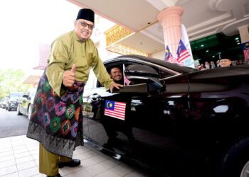 AB. Rauf Yusoh melekatkan Jalur Gemilang di sebuah kenderaan di Lobi Blok Bendahari, Kompleks Seri Negeri, Ayer Keroh, Melaka. - UTUSAN/AMRAN MULUP