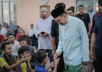 ANWAR Ibrahim bersalaman dengan kanak-kanak ketika hadir menunaikan solat Jumaat di Surau Al-Muttaqin, Presint 5, Putrajaya hari ini.-UTUSAN/FAIZ ALIF ZUBIR