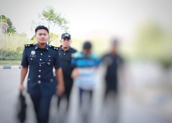 TERTUDUH semasa dibawa oleh polis untuk prosiding perbicaraan di Mahkamah Sesyen, Kota Bharu, Kelantan.-UTUSAN/KAMARUL BISMI KAMARUZAMAN.