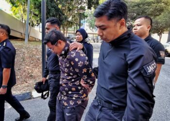 ZULAZREN Zakariah dibawa anggota polis bagi berdepan pertuduhan membunuh di Mahkamah Majistret Seremban hari ini.-UTUSAN/MOHD. SHAHJEHAN MAAMIN