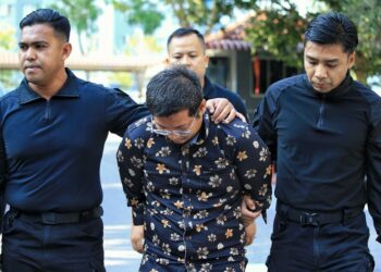 ZULAZREN Zakariah dibawa anggota polis bagi berdepan pertuduhan membunuh di Mahkamah Majistret Seremban hari ini.-UTUSAN/MOHD. SHAHJEHAN MAAMIN