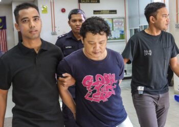 NGUYEN Minh Hoa (tengah) diiringi oleh beberapa anggota polis ketika tiba di Mahkamah Majistret Butterworth, Pulau Pinang hari ini.-UTUSAN/DANIAL SAAD
