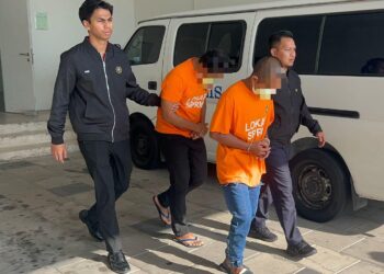 DUA penjawat awam dibawa keluar selepas mendapat permohonan reman berhubung kes salah guna jawatan di Kompleks Mahkamah Kangar, Perlis, hari ini. -UTUSAN/ASYRAF MUHAMMAD