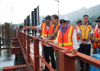 FARIZAN Darus (kiri) menunjukkan sesuatu kepada Ramli Ngah Talib (dua dari kiri) ketika sesi lawatan ke tapak projek Pulau Silikon di Pulau Pinang, hari ini.