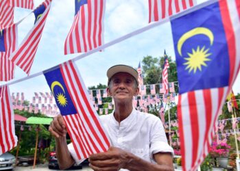 ABDUL Raship Khalil memasang Jalur Gemilang di sekitar rumahnya sempena sambutan Hari Kemerdekaan di Kampung Permatang Duyong, Melaka, semalam. - UTUSAN/ARIF HAMIZAN MISKON