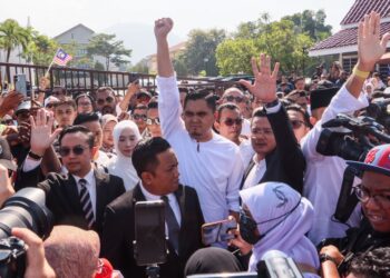 DR. Muhamad Akmal Saleh (tengah) mengangkat tangan kepada kumpulan penyokong yang menunggunya sebaik sahaja keluar dari pekarangan Kompleks Mahkamah Bukit Mertajam di Pulau Pinang hari ini.-UTUSAN/DANIAL SAAD