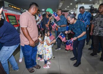 FAHMI Fadzil ketika sesi menyerahkan Jalur Gemilang kepada orang awam pada program Denyut Nadi Merdeka Rapid KL Hidupkan Semangat Bulan Kebangsaan 2025 di Stesen LRT Pasar Seni di sini, hari ini. - UTUSAN/SYAKIR RADIN