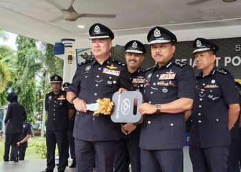 MOHD. Yusoff Mamat (kanan) menyerahkan kunci kenderaan kepada Ketua Polis Daerah Gua Musang Superintendan Sik Choon Foo untuk kegunaan pasukan berkenaan selepas merasmikan Perhimpunan Bulanan di Ibu Pejabat Polis Kontinjen (IPK) Kelantan, Kota Bharu, Kelantan hari ini-UTUSAN/YATIMIN ABDULLAH.