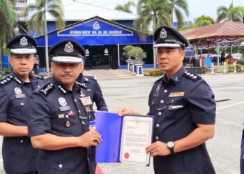 MOHD. Yusoff Mamat (kiri) menyerahkan surat penghargaan kepada pegawainya yang berkhidmat cemerlang semasa Perhimpunan Bulanan Polis di Ibu Pejabat Polis Kontinjen (IPK) Kelantan, Kota Bharu, Kelantan hari ini-UTUSAN/YATIMIN ABDULLAH.