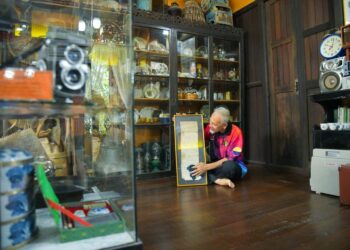 MOHAMAD Jusoh Md. Isa mengelap bingkai manuskrip lama sekitar tahun 1900 berkaitan petua ubat-ubatan tradisional yang masih disimpan di galerinya di Kampung Mata Ayer, Arau, Perlis semalam. -UTUSAN/IZLIZAN OTHMAN
