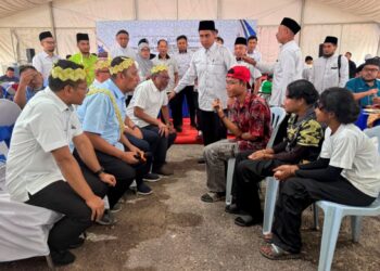 FARIZAL Johari (duduk, tiga dari kanan) ketika mengucap dua kalimah syahadah bersama dua anak saudaranya di Rancangan Penempatan Semula (RPS) Sungai Bilut di Raub, Pahang.