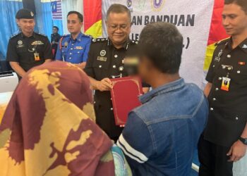 ROSMAH ditemani ayahnya ketika menerima surat aku janji sempena PBSL Sempena Hari Kebangsaan dan Hari Malaysia di Penjara Kluang, Johor. - UTUSAN/ADNAN IBRAHIM
