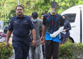GURU lelaki (kanan) yang didakwa mengelar leher isterinya dalam kejadian di Taman Tunas Muda, Sungai Ara, Rabu lalu dibawa ke Mahkamah Balik Pulau, Pulau Pinang hari ini.-UTUSAN/DANIAL SAAD