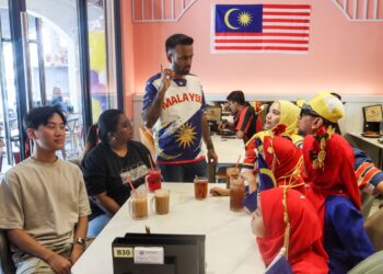 MOHAMMAD Nasmir Kadhar Shah (berdiri, tengah) berbual bersama pelanggan yang berkunjung ke Restoran Nasi Kandar Nasmir di Batu Kawan, Pulau Pinang hari ini.-UTUSAN/DANIAL SAAD