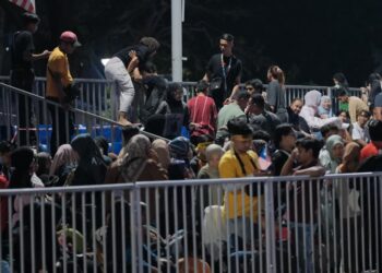 RATUSAN pengunjung sambutan Hari Kebangsaan 2025 bertindak memanjat pagar bagi mendapatkan tempat duduk awam yang dikhaskan. - UTUSAN/FAIZ ALIF ZUBIR