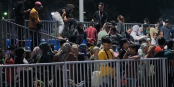 RATUSAN pengunjung sambutan Hari Kebangsaan 2025 bertindak memanjat pagar bagi mendapatkan tempat duduk awam yang dikhaskan. - UTUSAN/FAIZ ALIF ZUBIR