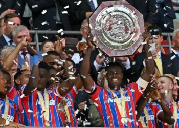 Pemain pertahanan Crystal Palace, Marc Guehi menjulang Perisai Komuniti sambil diraikan rakan sepasukan selepas menewaskan penyandang juara Liga Perdana Inggeris (EPL), Liverpool 3-2 dalam penentuan sepakan penalti susulan kedua-duanya terikat 2-2 dalam perlawanan sebenar di Stadium Wembley, London, semalam. – AFP