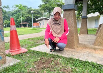 NORIZAN Esa menunjukkan kesan tanah yang dikambus di lokasi mayat bayi lelaki berbalut kain lampin ditemukan di Program Perumahan Rakyat (PPR) Gua Musang, Kelantan. - UTUSAN/AIMUNI TUAN LAH