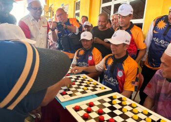 MUHAMMAD Faiz  Fadzil (duduk dua dari kanan) mencuba permainan dam aji selepas Majlis Perasmian Sambutan Gelombang Samudera Madani Kelantan di Pantai Sri Tujoh Tumpat, Kelantan. - UTUSAN / ROSLIZA MOHAMED
