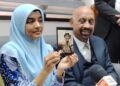 UMMU Haiman Bee Daulatgun (kiri) menunjukkan gambar anaknya dalam sidang akhbar bersama Naran Singh di Ipoh, baru-baru ini. - UTUSAN