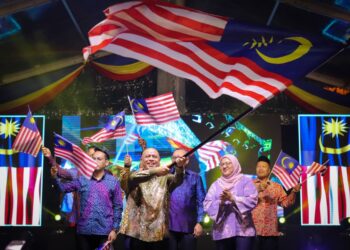 SAARANI Mohamad mengibarkan Jalur Gemilang pada Majlis Peluncuran Bulan Kebangsaan di Bulatan Sultan Azlan Shah, Ipoh hari ini. - UTUSAN/MUHAMAD NAZREEN SYAH MUSTHAFA