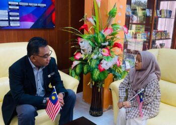 NURSYAHIRAH Najihah Muhamad Rabani menerima Jalur Gemilang daripada Mohamad Kelana Juwit sebagai simbolik sambutan Hari Kebangsaan Ke-68 di KKJS, Melaka.